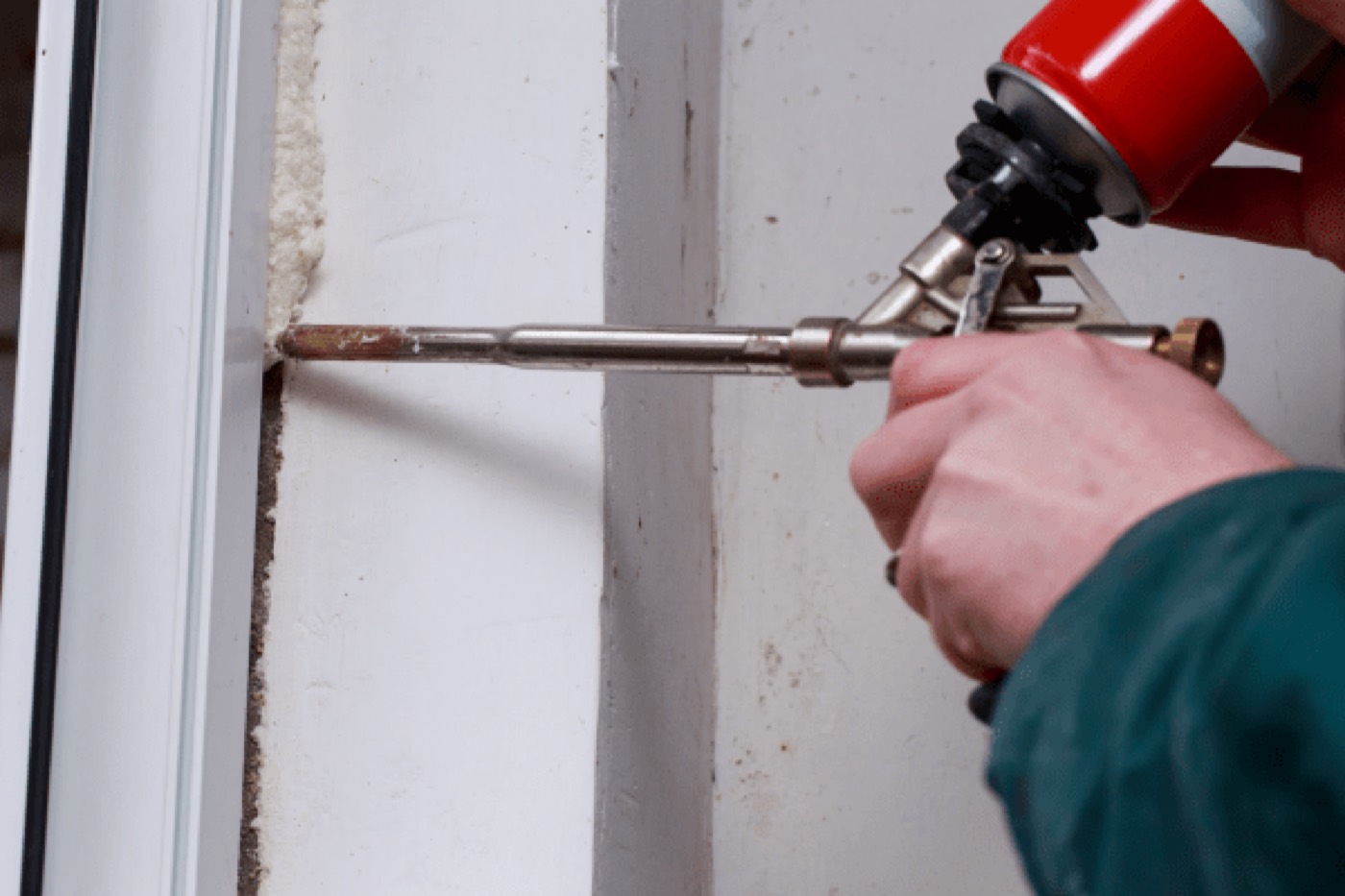 Expanding foam being gunned in around the edge of an installed window