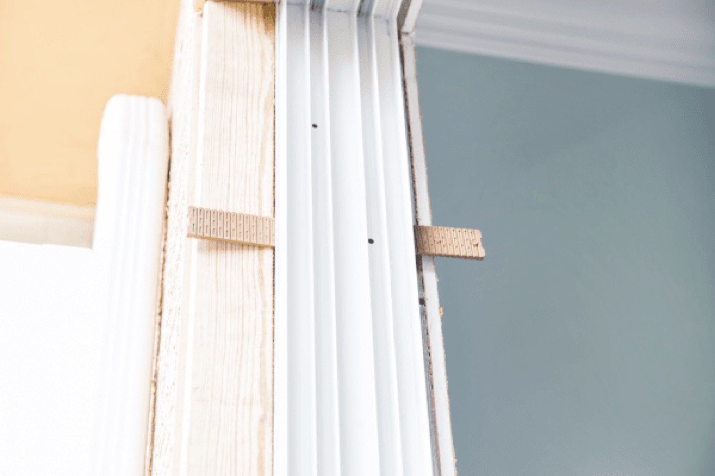 Shims being tapped in along the side of a window frame during installation